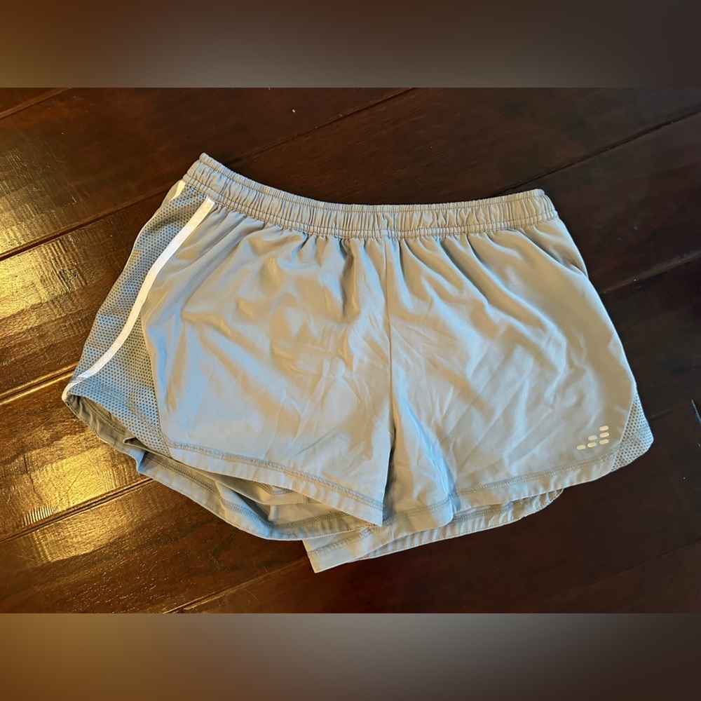 light gray gym shorts with white accents on side of shorts